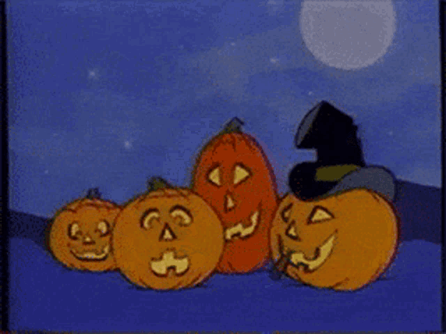 a group of pumpkins with one wearing a witch hat with the letter g on it