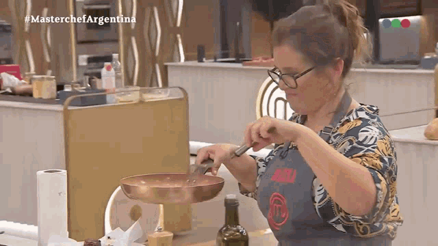 a woman in an apron with the letter m on it prepares food