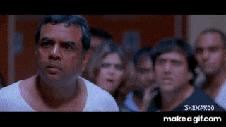 a man in a white shirt is standing in front of a crowd of people and says make a gif.com on the bottom