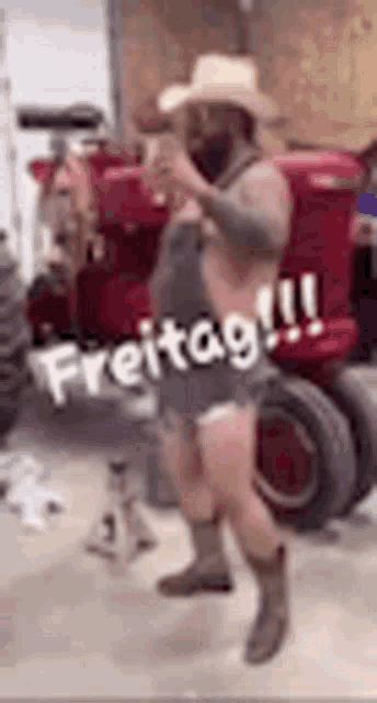 a man in a cowboy hat and shorts is dancing in front of a tractor .