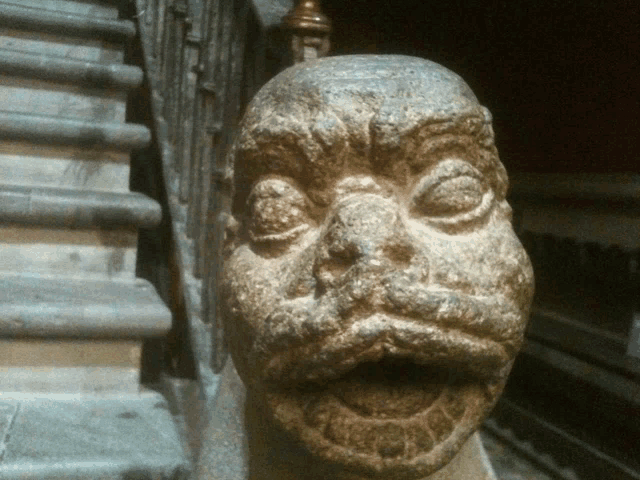 a statue of a man 's face with his mouth open and stairs in the background