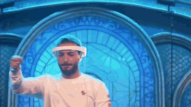 a man wearing a face shield is dancing in front of a blue door