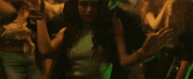 a man in a cowboy hat is dancing in a crowd of people at a party .