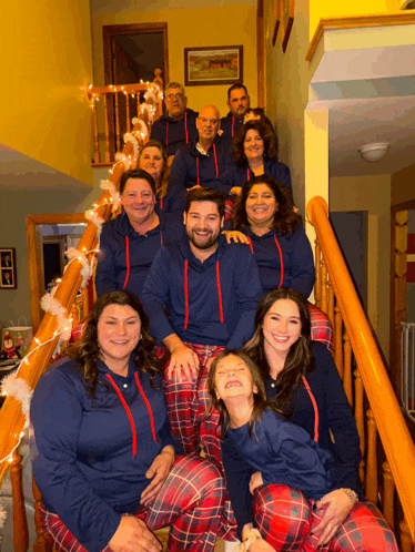 a family posing for a picture on the stairs wearing pajamas