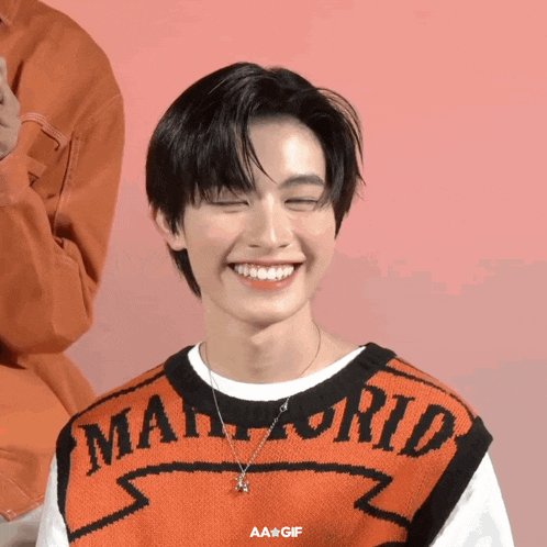 a man wearing an orange sweater that says mario