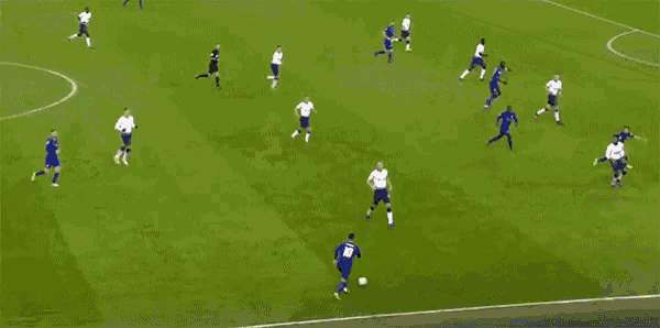 a soccer game is being played on a field with players in white and blue