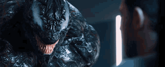 a close up of venom 's mouth looking at a man