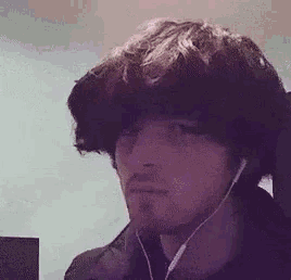 a man with a beard is wearing ear buds