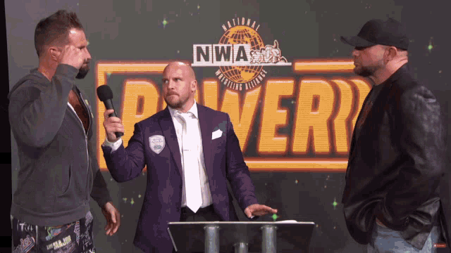 two men are standing in front of a sign that says nwasdr