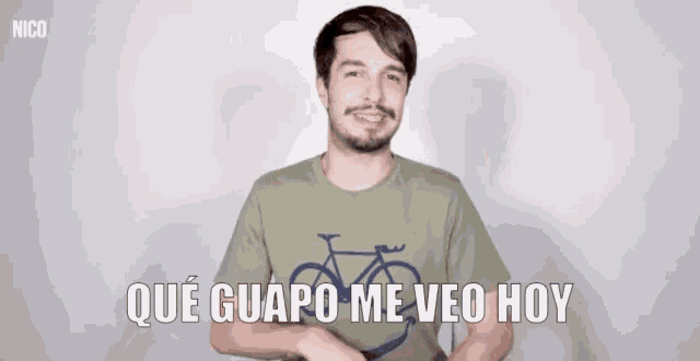 a man wearing a t-shirt with a bicycle on it and the words que guapo me veo hoy