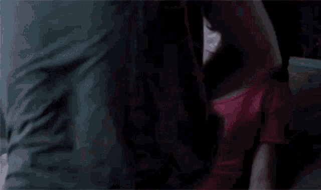 a woman in a pink shirt is looking at a man 's torso .