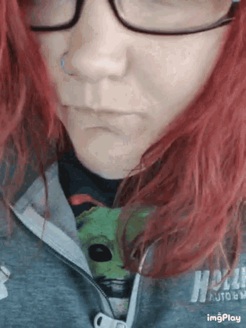 a woman with red hair is wearing glasses and a hoodie that says hell auto on it