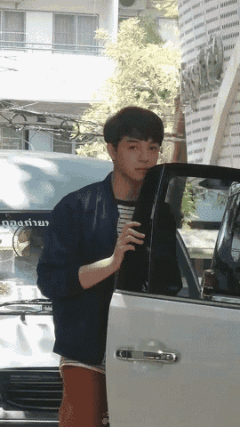 a young man is getting out of a white car with a sign that says ' a ' on it