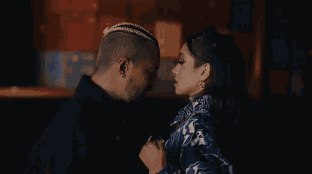 a man and a woman are looking at each other in the dark