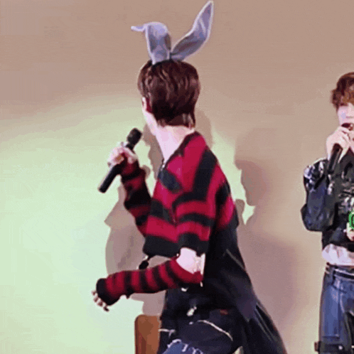 a man wearing bunny ears holds a microphone