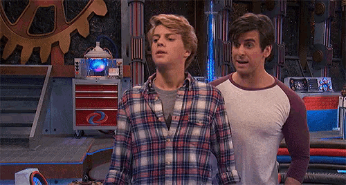 a man in a plaid shirt stands next to a man in a white shirt