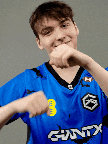 a young man wearing a blue shirt that says giantx