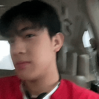 a young man is sitting in the back seat of a car and taking a selfie .