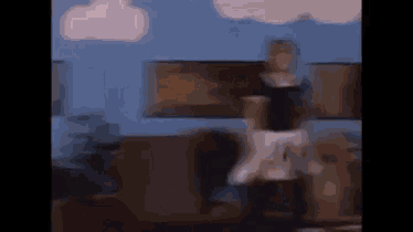 a blurry picture of a woman dancing in a living room with a cloud in the background .