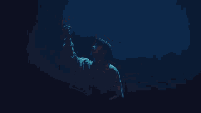 a man in a grey shirt is holding a light in his hand