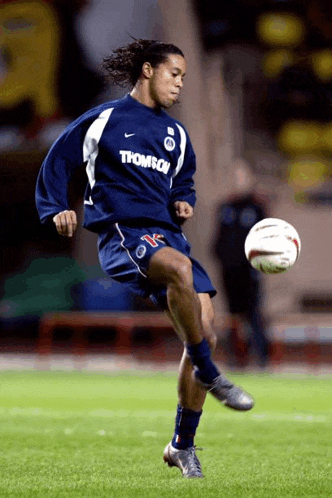 a soccer player wearing a shirt that says thomson kicks a ball