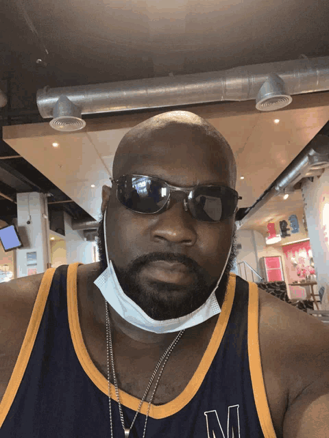 a man wearing a mask and sunglasses is wearing a jersey that has the letter m on it