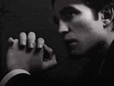 a man in a suit is touching another man 's foot