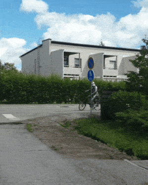 a man is riding a bike in front of a building with a sign that says no parking