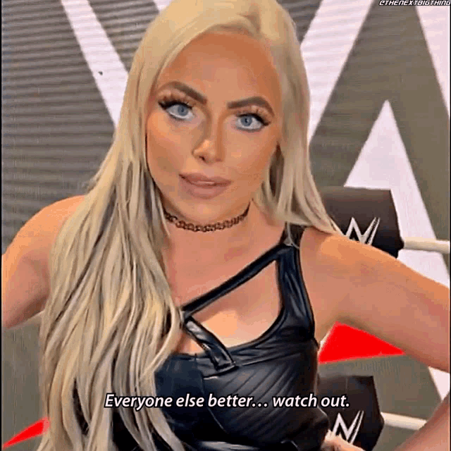 a woman with blonde hair and blue eyes is wearing a black top and choker and says everyone else better watch out
