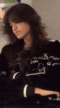 a woman wearing a black jacket that says ' i love you ' on the sleeves