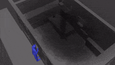 an aerial view of a dark room with a person standing in the middle