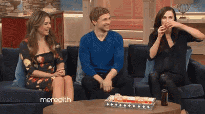three people sitting on a couch with meredith written on the bottom right