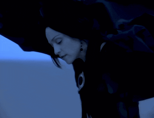a woman in a black dress with a blue background