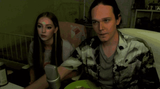 a man and woman sitting in front of a microphone