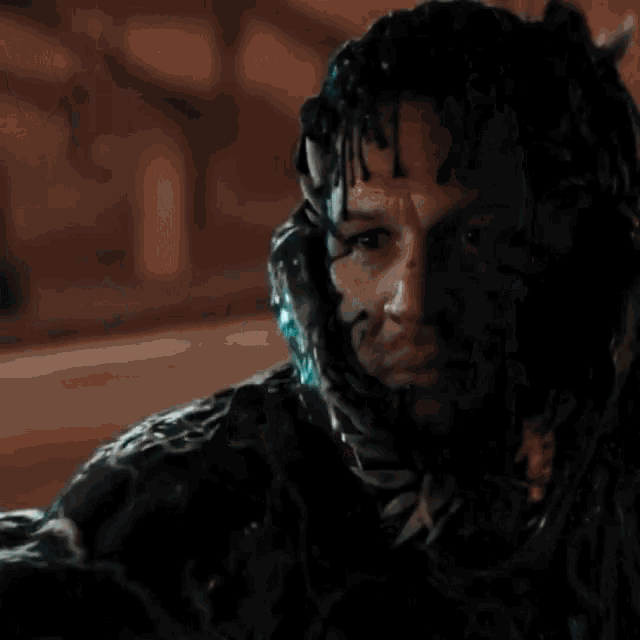 a close up of venom 's face with his mouth open and fangs coming out of it .