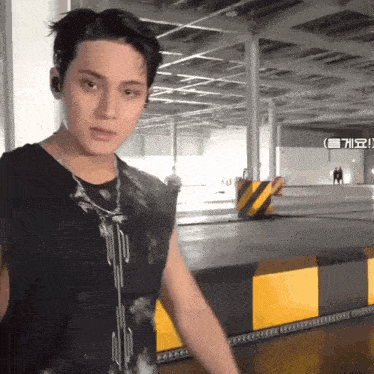 a young man in a black shirt is standing in a parking lot