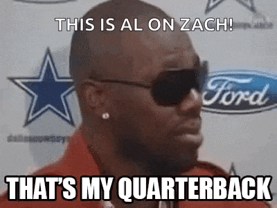 a man wearing sunglasses and a red shirt is standing in front of a ford logo and a cowboys logo .
