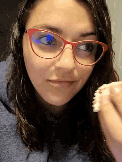 a close up of a woman wearing glasses and a blue sweatshirt