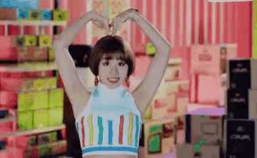 a woman is making a heart shape with her hands .