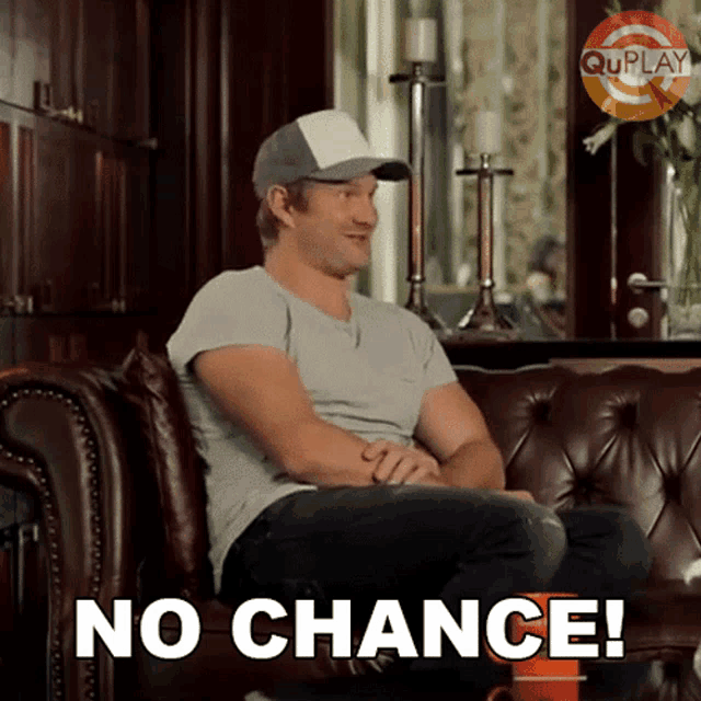 a man sitting on a couch with the words no chance written on the bottom