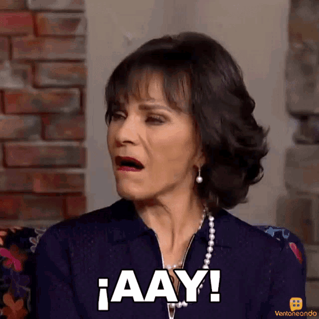 a woman with a surprised look on her face says aay in white letters