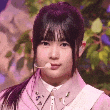 a close up of a girl wearing a ponytail with a microphone