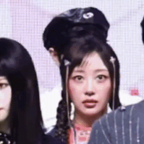 a woman with a bun in her hair is standing next to a man and a woman .