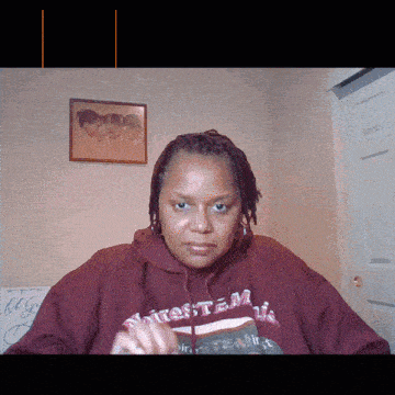 a woman wearing a maroon sweatshirt that says " firestem " looks at the camera