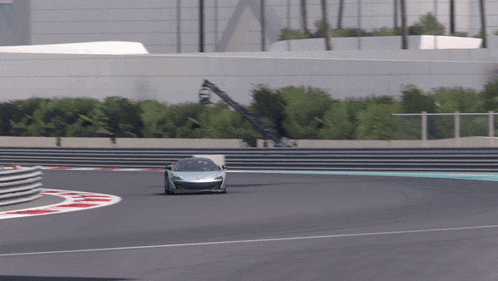 a car is driving on a race track with a red stripe on the side