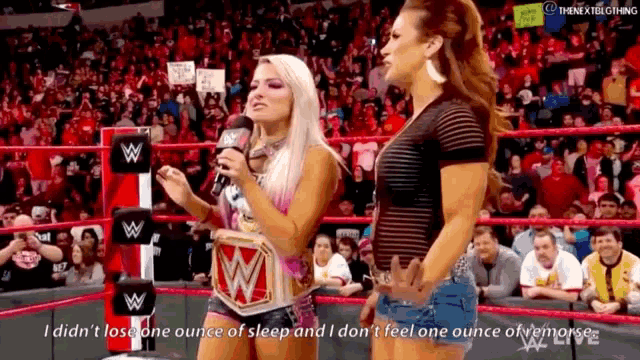 two women are talking to each other in a wrestling ring while holding microphones .