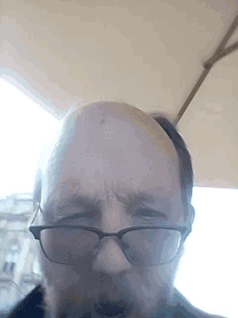 a man with glasses and a beard is looking at the camera