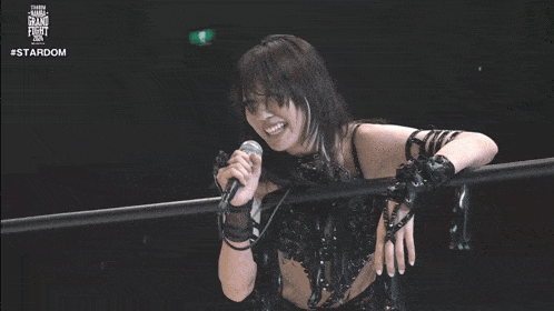 a woman is singing into a microphone while standing in a ring ..