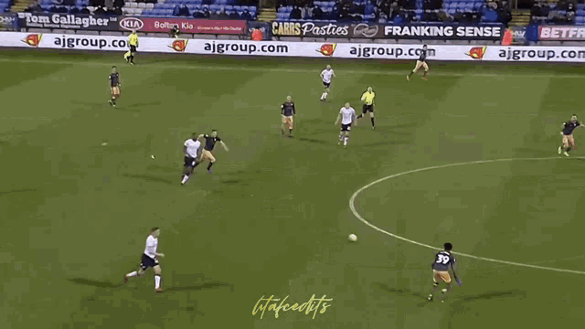 a soccer game is being played on a field with advertisements for ajgroup.com and franking sense