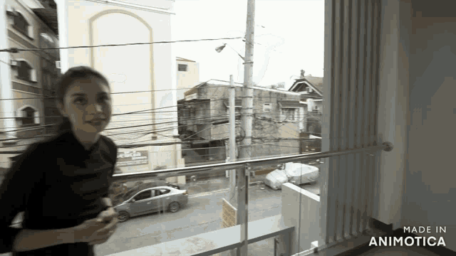 a woman standing on a balcony with the words made in animotica on the bottom right